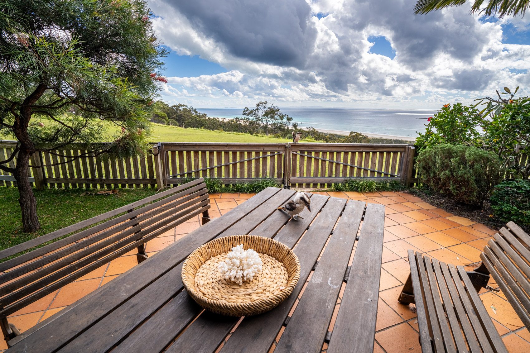 The private deck of a Prestige Headland Ocean 3 bedroom villa, with outdoor dining looking over the headland to the ocean