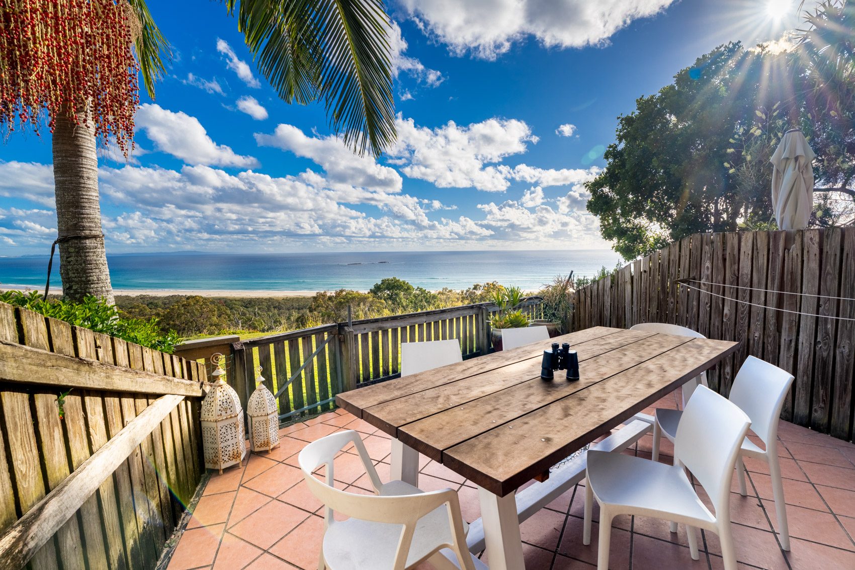 The private deck of a Prestige Headland Ocean villa, with outdoor dining looking over the headland to the ocean