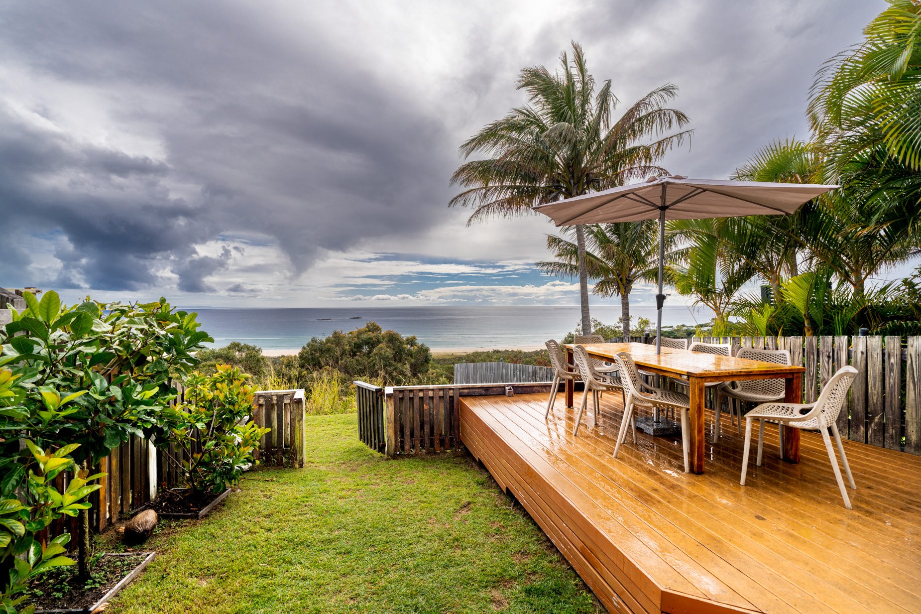 The private deck of a Prestige Headland Ocean 3 bedroom villa, with outdoor dining looking over the headland to the ocean