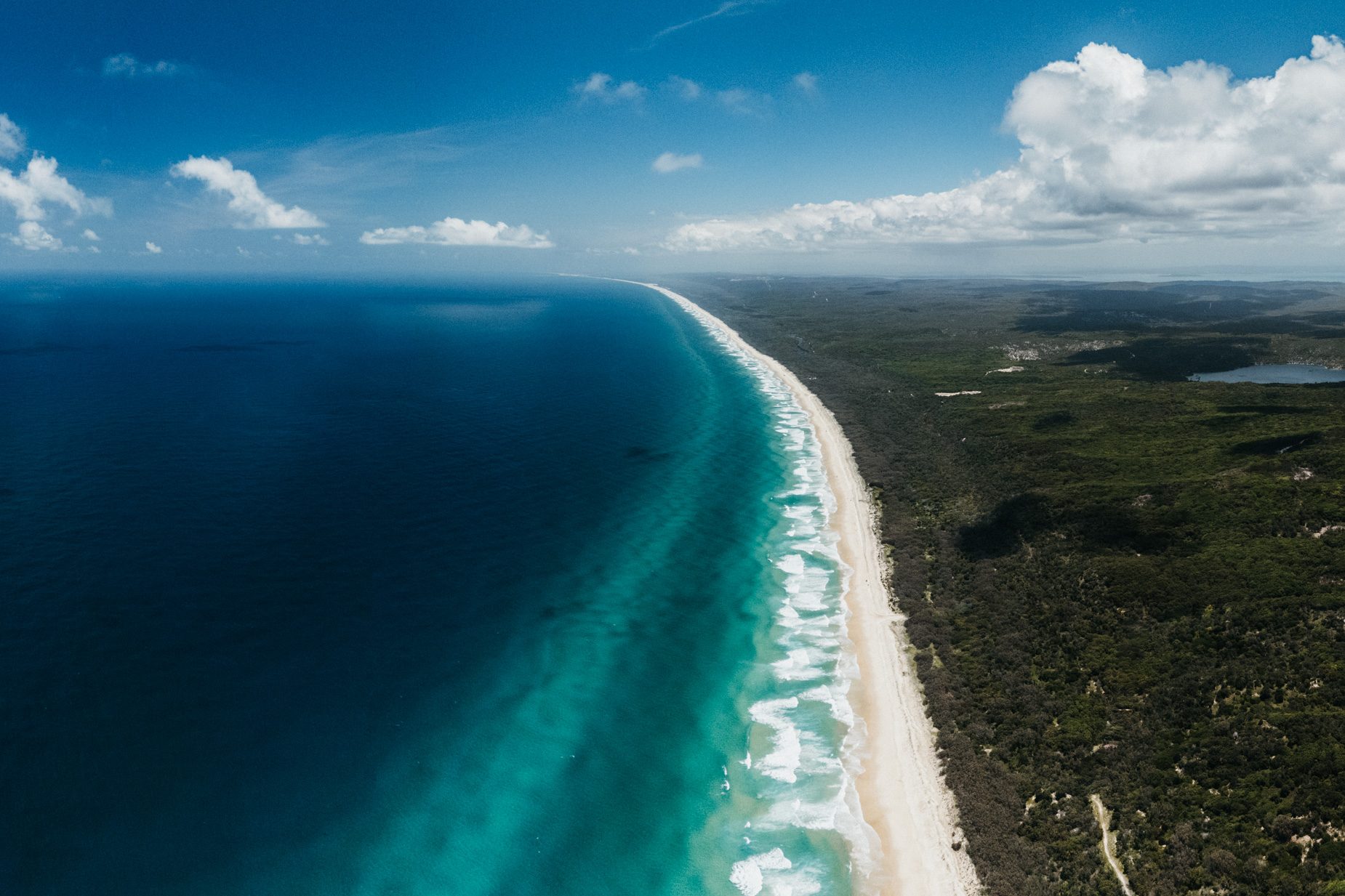 Main Beach on North Stradbroke Island from the air, surf rolling onto the long white beach
