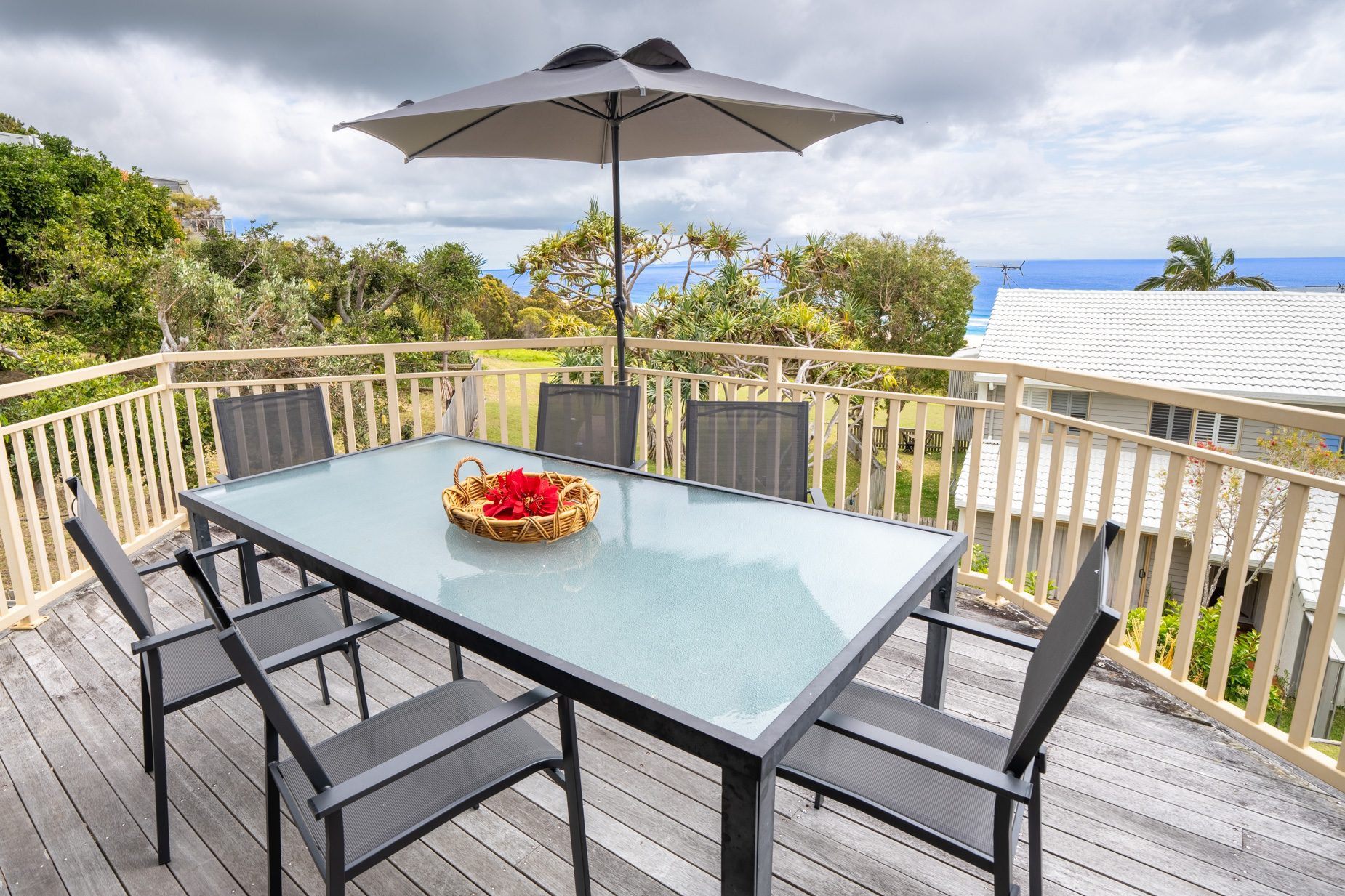 The balcony dining setting looking over the treetops to the ocean from the Standard Headland Ocean 3 Bedroom villa
