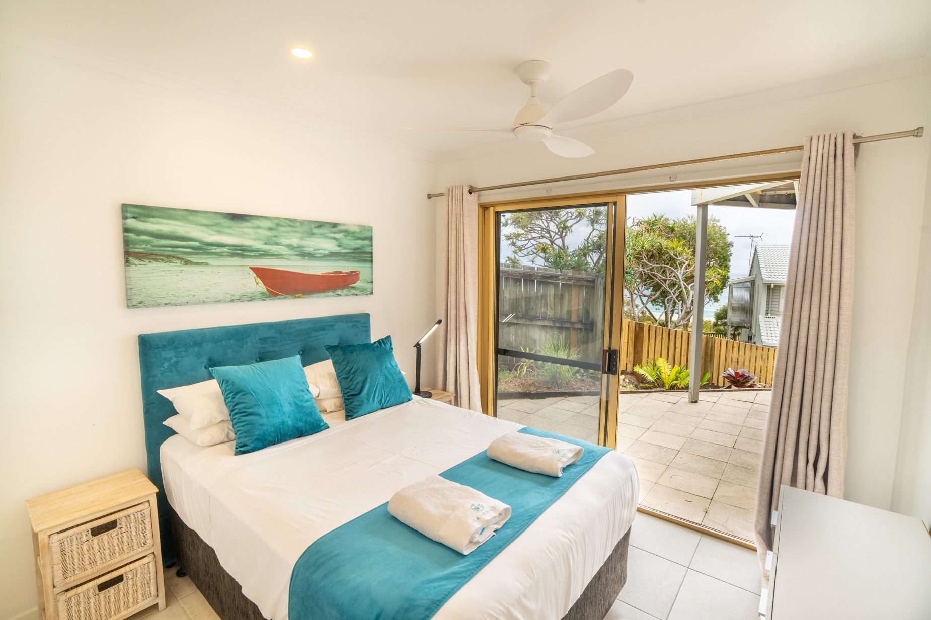A queen bedroom opening onto the courtyard in the Standard Headland Ocean 3 Bedroom villa